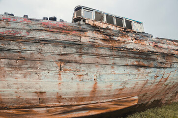 An old wooden shipwreck, showing signs of decay and deterioration. An old nautical sea vessel...