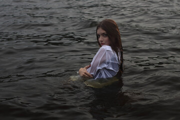 Young woman in the black water dressed white shirt