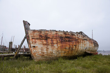 An old wooden shipwreck, showing signs of decay and deterioration. An old nautical sea vessel...