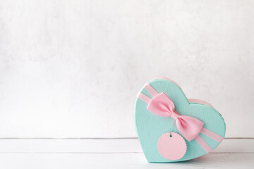 blue heart Gift or present box with pink bow and tag on white background, greeting card for Valentines day.