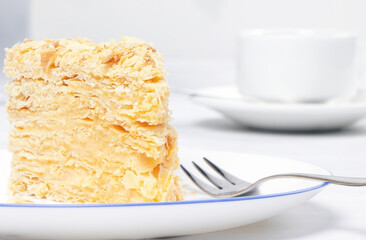 Napoleon Cake on a white plate. Traditional French dessert. Cake Napaleon of puff pastry on white background