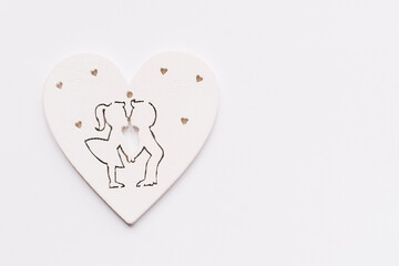 Frame for text white wooden hearts couple in love, girl and boy kissing.Cutting plywood texture using cnc laser. Top view on white background Valentine's Day. Copyspace.