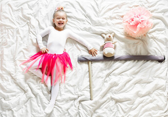 beautiful joyfully smiling blonde girl, lies on a crumpled blanket, depicting a ballerina