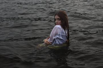 Sexy woman in the water.Dressed wet white shirt