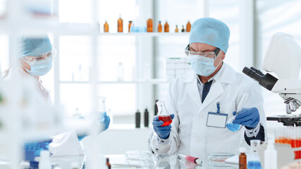 scientists colleagues checking the liquid in laboratory flasks.