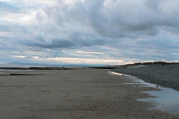 relaxing and gentle calming waves flowing into a beach on an gloomy overcast day