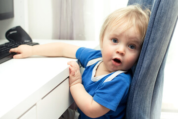 Little baby boy geek playing with computer and he is surprised. Children, technology online...