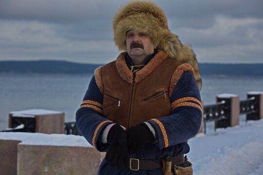 A Man In A Historical Sami Costume On The Embankment Of Lake Onega.