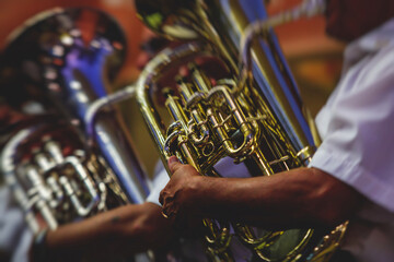 Concert view of an jazz orchestra tubist Tuba player performs with musical jazz band and audience...