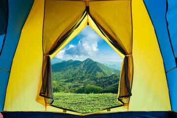 open tent with greenery mountains landscape view against blue sky and large clouds © OHishi_Foto