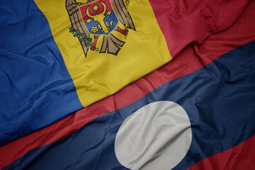 waving colorful flag of laos and national flag of moldova.