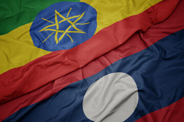 waving colorful flag of laos and national flag of ethiopia .