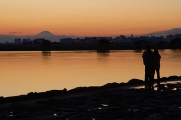 Naklejka na ściany i meble 葛西臨海公園夕景　富士山と夕焼けを眺める人たちのシルエット
