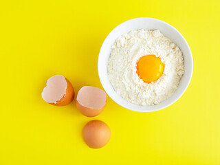 Flour with egg. Flat lay composition on yelow background