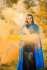 Woman in blue cloak and black dress, costumes for ladies. Girl in glamourous mascaraed dress