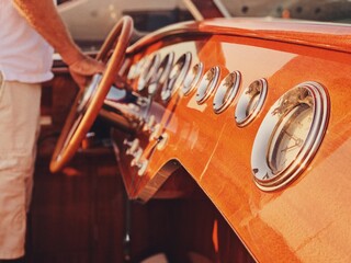 Detail of the dashboard of a vintage motorboat at sunset