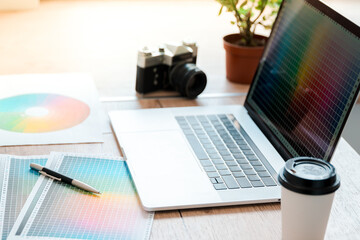 close up. laptop, camera and color palette on the table of designer .