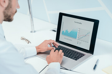 business man using a laptop to analyze financial data .