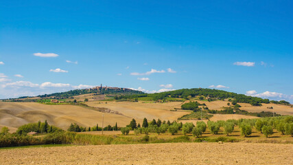 The late summer landscape around Monticchiello near Pienza in Val d'Orcia, Siena Province, Tuscany, Italy. Monticchiello village can be seen on the hill in the background
