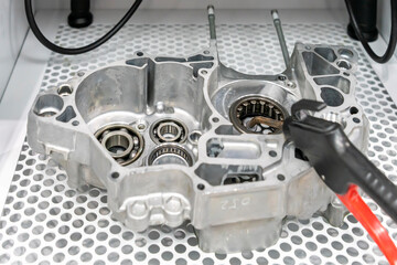 Aluminum automobile part and sand blast gun on mesh in sandblast machine room of cleaning...