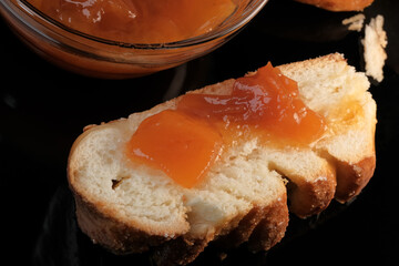 A slice of white bun with peach jam