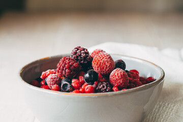 close up of red frozen fruits in bowl
