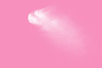 White powder explosion on pink background.