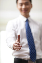Portrait of young businessman executives extending hands to shake