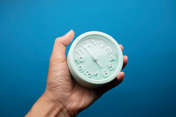 Human Hand Holding Alarm Clock