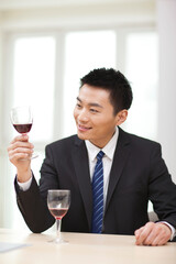 Portrait of businessman at desk with a glass of wine