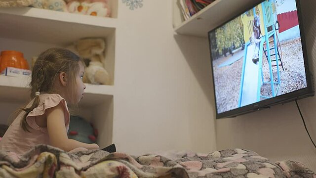 a little girl watching children's programs on the TV