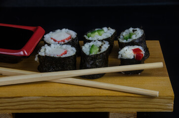 Leckere suhsi mit einen pssenden Brett, Stäbchen und Sojasose 