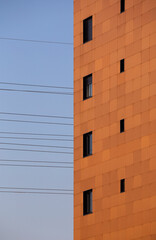 Orange apartment building windows against a clean blue sky, Braga.