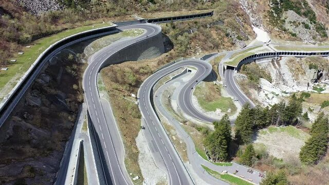 Aerial drone footage of the Saint Gotthard mountain pass road in a very narrow valley near Andermatt in Canton Uri in the alps in Switzerland. Shot with a tilt down motion
