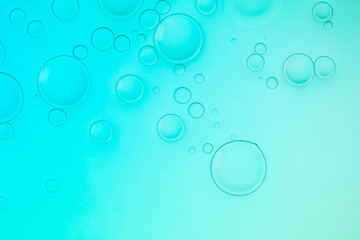 Creative neon background with drops. Glowing abstract backdrop with vibrant gradients on bubbles. Turquoise overflowing color