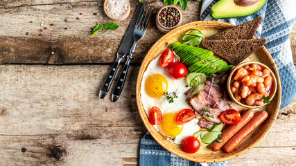 full english breakfast beans, fried eggs sunny side up, bacon slices, sausages, tomatoes, avocado on white plate. catering, banner, menu, recipe, place for text