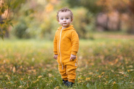 Little Boy In Yellow Overalls Posing In Autumn Park