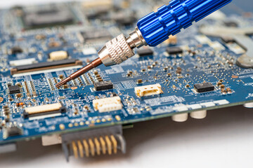 E-waste, technician repairing inside of hard disk by soldering iron. Integrated Circuit. the...