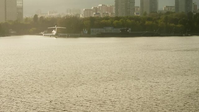 Faraway view of flare craft and model of black submarine on river Moskva in Moscow. Sunset in city
