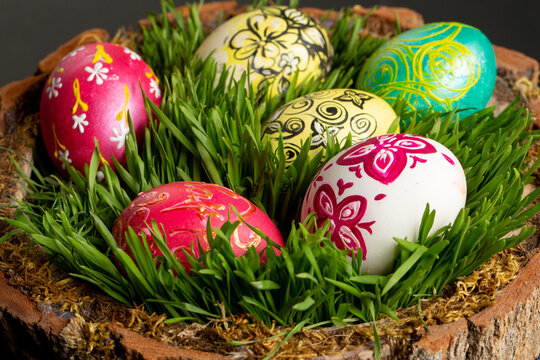 Many colored eggs with ornaments  on green grass