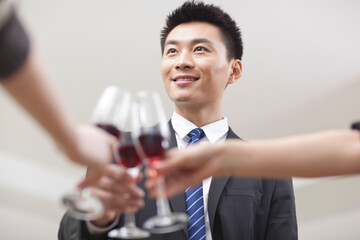 Portrait of businessman holding a glass of wine and toasting
