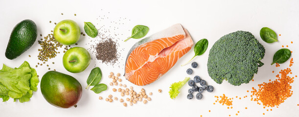 Set of food for healthy diet. Salmon, legumes, chia seeds, vegetables and fruits on white background. Food background with empty space