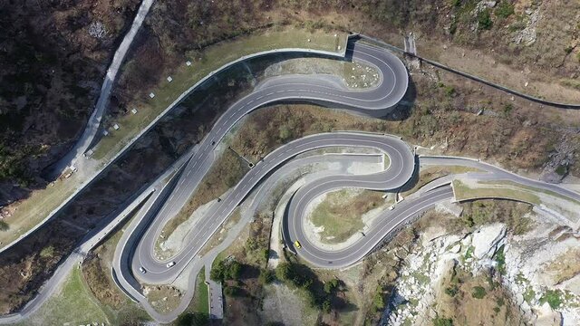 Aerial overhead drone footage of the Saint Gotthard mountain pass road in a very narrow valley near Andermatt in Canton Uri in the alps in Switzerland.