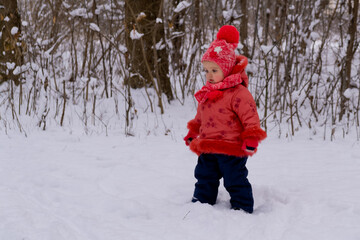 Baby girl walking on snow. Winter time.