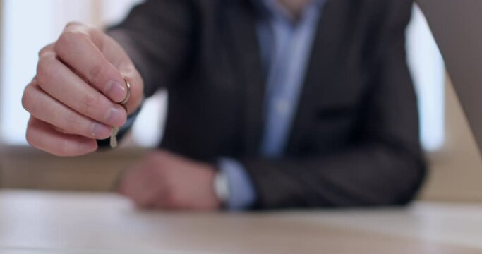 A Closed Lock Is On The Touchpad Of An Open Laptop, The Camera Moves To The Side On The Slider And Shows A Person With The Keys To The Lock In His Hand. Computer Security Under Lock And Key.