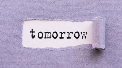 The text TOMORROW appears on torn lilac paper against a white background.