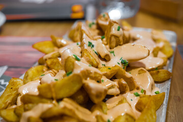 Delicious typical spanish tapas dish : patatas bravas (fried potatoes) with aioli sauce (garlic and olive oil basis). 