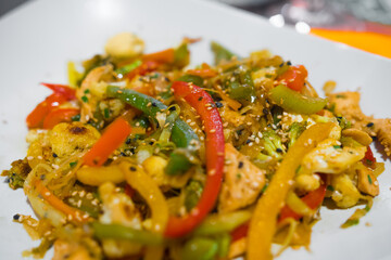 Delicious mixed vegetables on a plate with sesame seeds. Cooked with a wok. Typical asian cuisine.