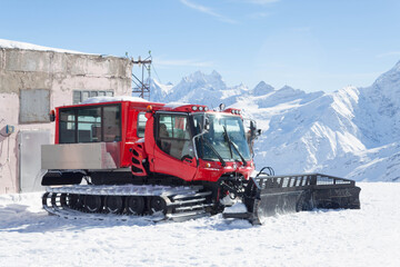 Tractor removing snow in the snow-white tall mighty mountains Elbrus, ski resort, the Republic of Kabardino-Balkaria, Russia