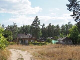 Russian village in summer, the house behind the fence, gloomy entourage